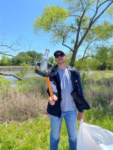 A young man holds trash removed from Weiss Lake.