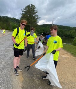 A group of teenagers remove trash from the side of the road near Weiss Lake.