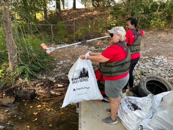 APSO volunteers use an extended grab tool to get trash just out of reach. (Joey Blackwell / Alabama News Center)