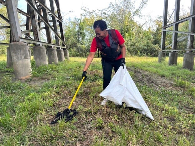 Dana McFarland helps clean the banks of the Coosa River. (Joey Blackwell / Alabama News Center)